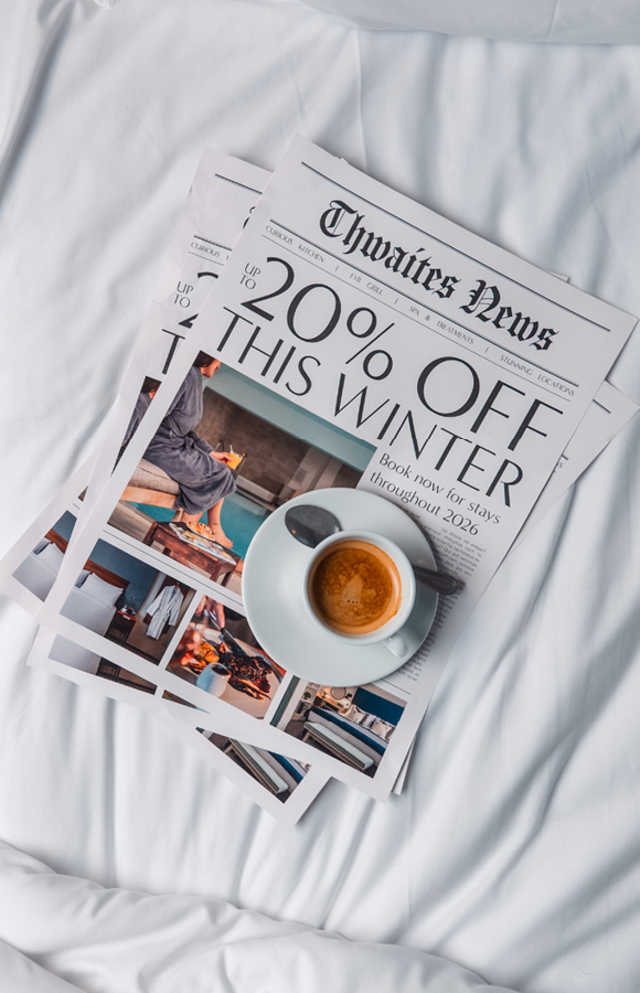 "up to 20% off this winter" newspaper with cup of coffee on bed
