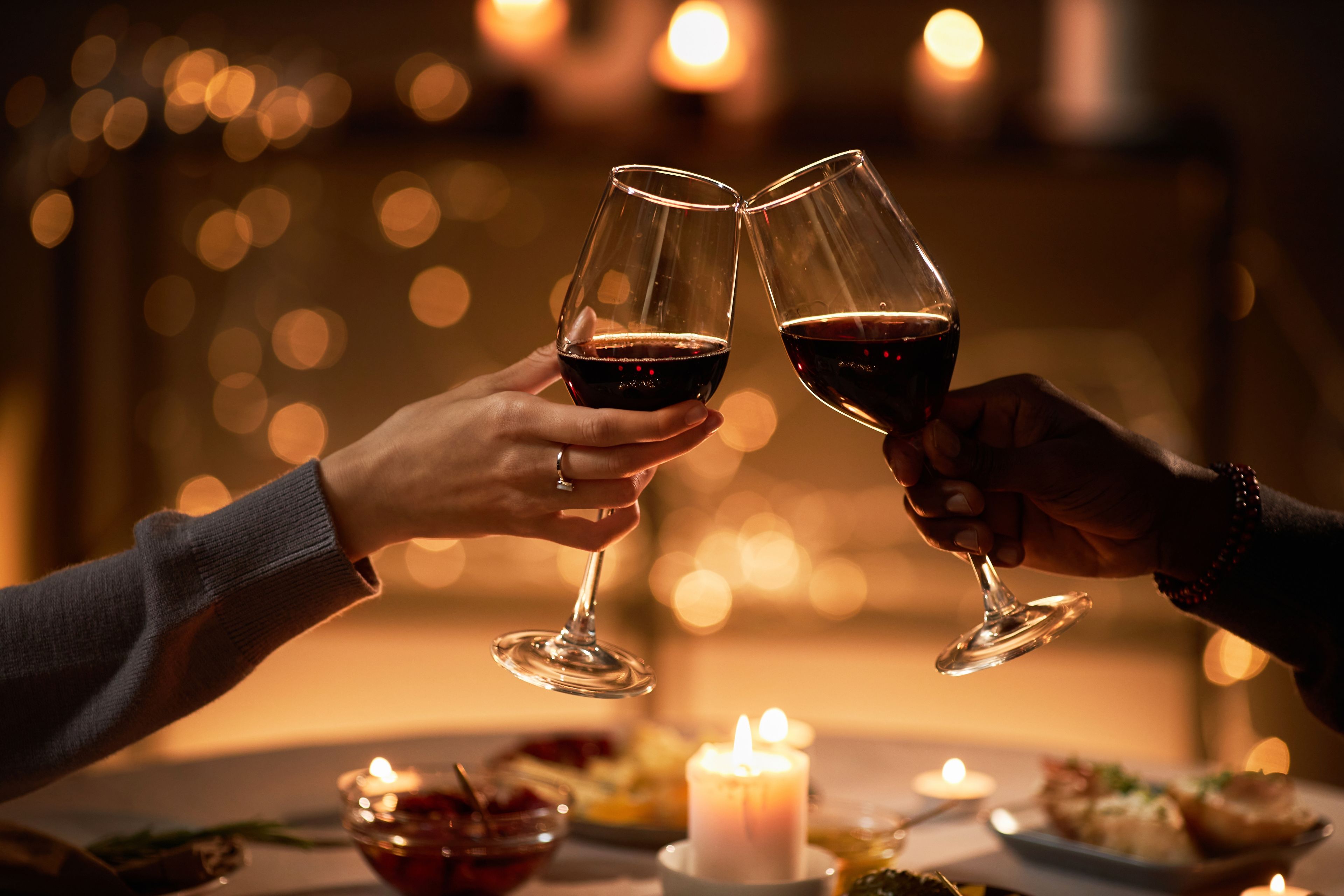 Couple having a meal toasting with red wine